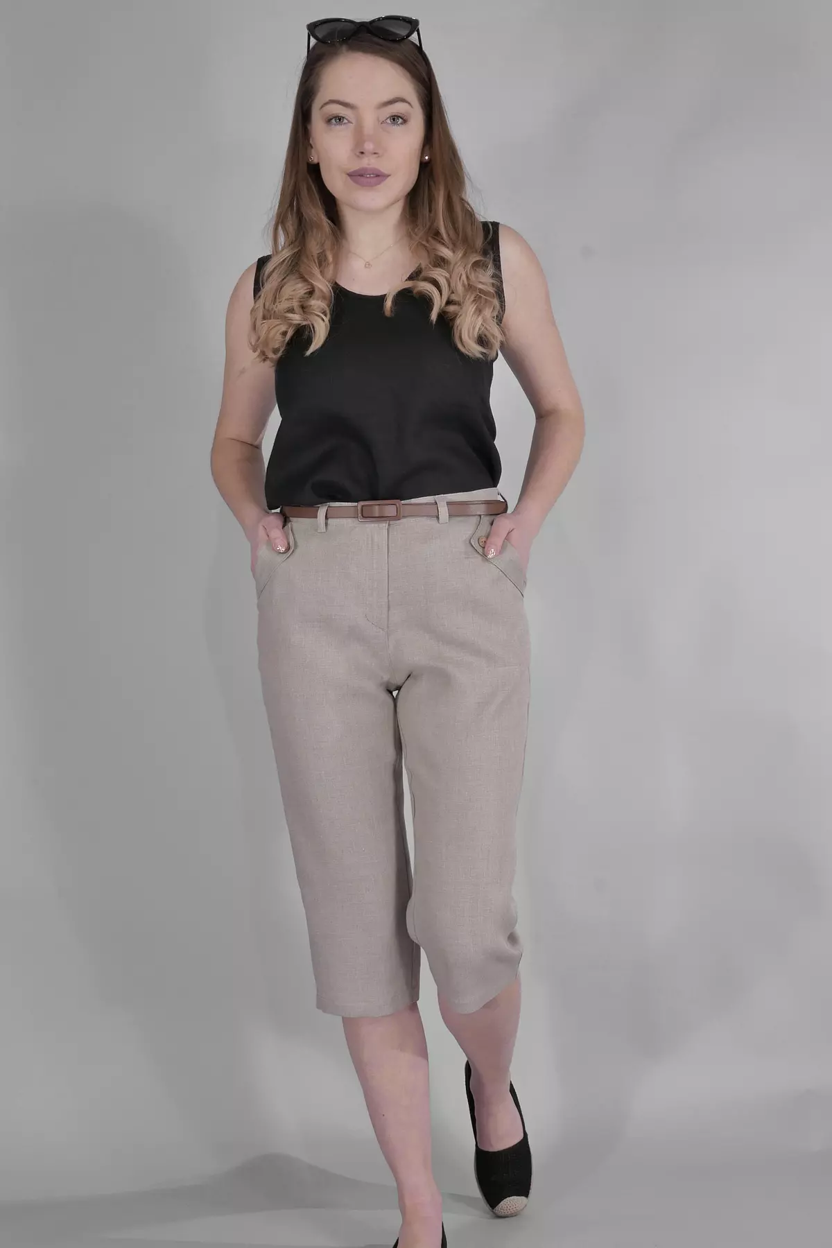 Modelka stoi w lekkim rozkroku, z okularami na głowie. Prezentuje beżowe rybaczki Nata w całej okazałości. Stylizacja jest swobodna, idealna na wakacyjne zwiedzanie.