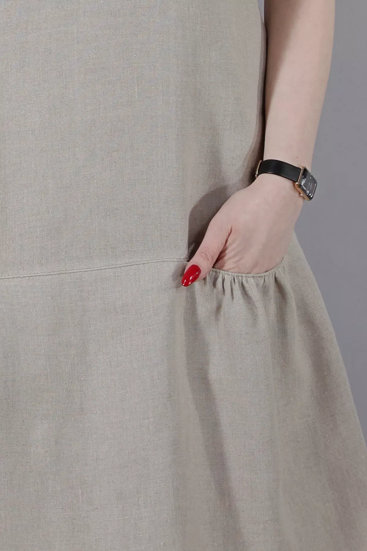 Zbliżenie pokazujące prawą kieszeń sukienki Dora uszytej z naturalnego lnu. Dłoń modelki jest wsunięta do kieszeni, co podkreśla jej wygodny i praktyczny krój.